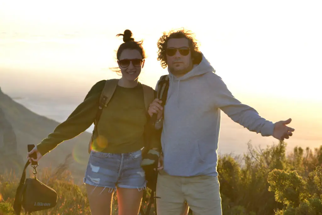 Elena e Matteo, fondatori di TERRABUCCI, sorridono al tramonto durante un’escursione: con zaini in spalla e sguardo aperto, raccontano lo spirito di un’ospitalità lenta, autentica e consapevole